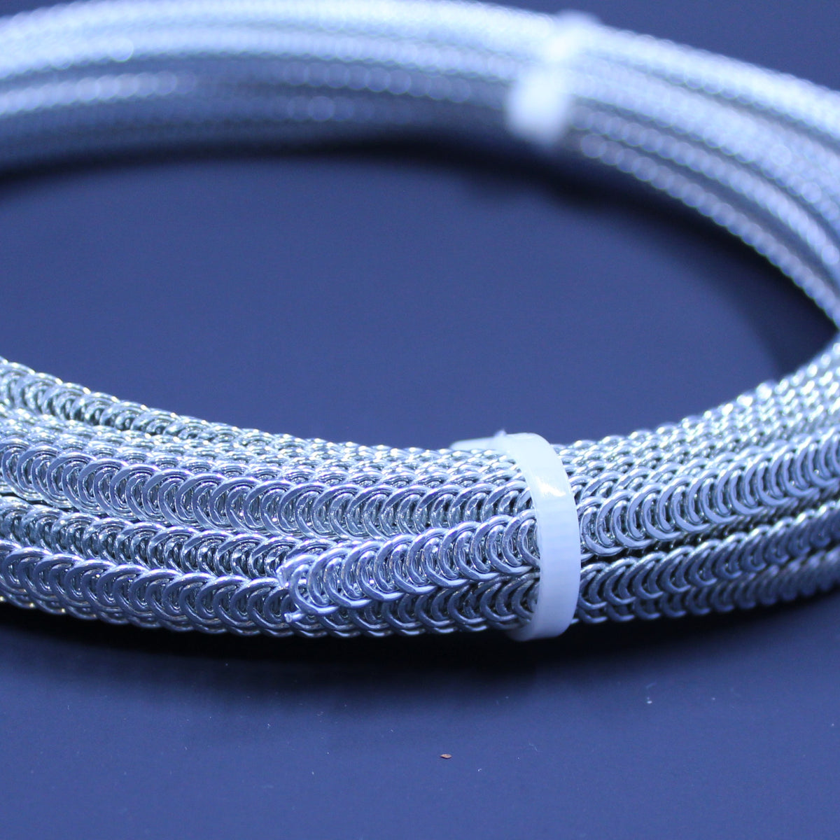 Coil of silver spiral steel boning, 6 mm wide, secured with a white tie