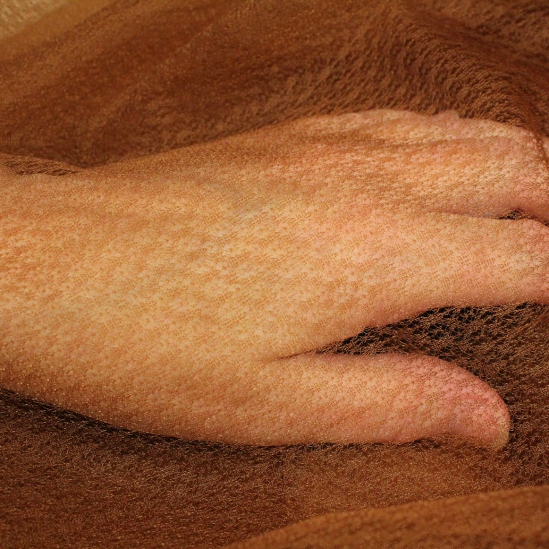 the fair skinned hand shows the texture of soufle. The coppery brown would disappear on darker skin